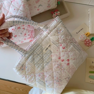 Detail of floral quilted tote bag with patchwork design and simple wish label