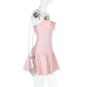 Détail de la robe rose courte avec fronces latérales et nœud décoratif sur le devant