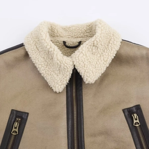 Close-up of faux shearling collar and textured leather surface on brown cropped jacket