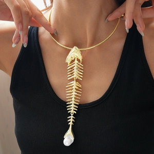 Detail of golden fishbone necklace with rhinestones and a baroque pearl drop
