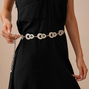 Detailed view of silver interlocking geometric rings chain belt on a black dress