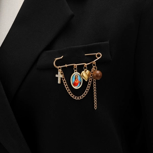 Détail des pendentifs croix et médaille sainte sur broche épingle dorée avec chaînes