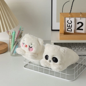 Close-up of cute plush pencil cases with soft white fur and detailed animal embroidery