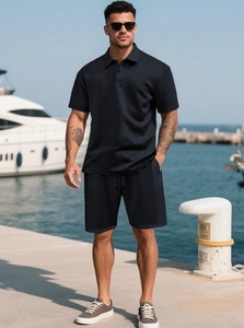 Detail of navy blue men's textured polo set with waffle knit fabric in seaside setting