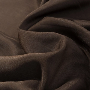 Close-up detail of dark brown bohemian blouse fabric showing high-quality woven texture
