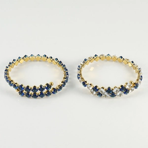 Detail of adjustable gold bracelets featuring square-cut blue and white zircon stones