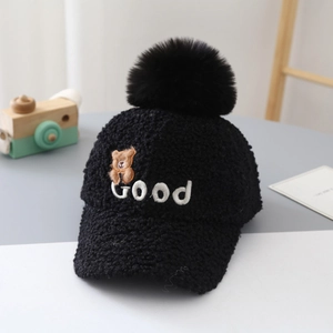 Close-up of black teddy fleece baseball cap with fuzzy pompom and bear embroidery