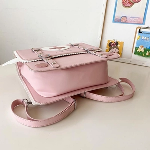 Pink JK style backpack detail with heart buckle and white lace trim on desktop