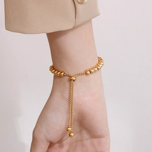 Bracciale a sfere regolabile placcato oro 18K con chiusura a cursore sul polso femminile