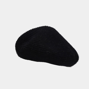 Close-up of the soft fuzzy texture and knit details of this black wool blend beret hat