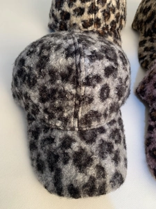 Macro detail of leopard print faux shearling fabric on a warm winter baseball cap