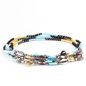Detail of bohemian multilayer beaded bracelet with colorful beads and shell charms