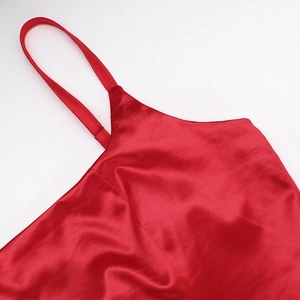 Détail de la robe en soie rouge montrant l'encolure à bretelles et le satin brillant