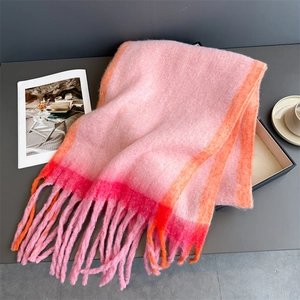 Detail of pink and orange striped cashmere-like scarf featuring soft fringe and fluffy texture