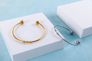 Polished stainless steel open cuff bracelets with spherical ends in gold and silver finish