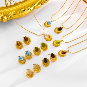 Flat lay of vintage gold jewelry collection with colorful oval turquoise and gemstones