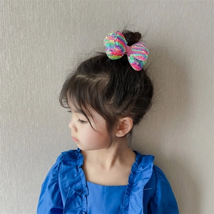 Girl wearing a colorful gradient sequined double bow hairclip for stage performances
