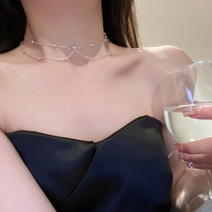 Double-layered silver choker necklace with bead detail on model neck close-up