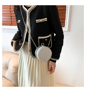 Macro shot of silver glitter round clutch with gold metal trim and chain strap