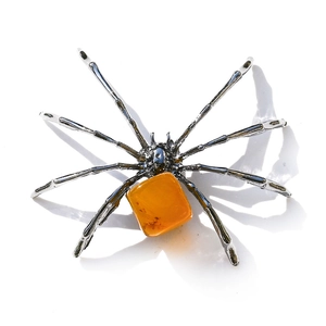Macro shot of spider craft with silver legs and translucent amber gemstone body