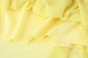 Detail of yellow mesh fabric and lining on the ruffle summer slim maxi dress