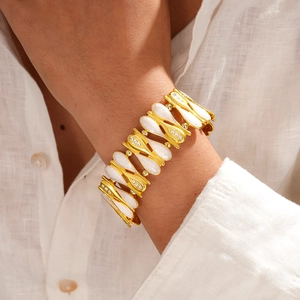 Dettaglio di un bracciale vintage dorato con gocce di zircone sul polso di una modella