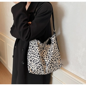 Vue détaillée du grand sac seau à imprimé léopard porté avec un manteau noir