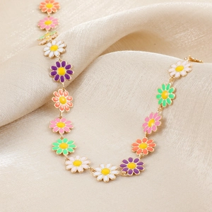 Colorful enamel daisy flower choker necklace with golden chain on silk fabric