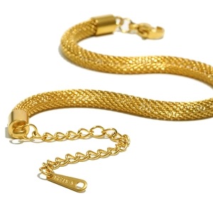 Détail macro de la chaîne en maille acier inoxydable doré 18K avec extension ajustable