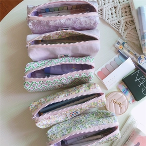 Vista plana de estuches de lona con flores con encaje morado crema y detalles de pana fina