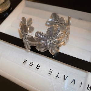 Macro detail of vintage floral cuff bangle with S925 silver finish and radial petal textures