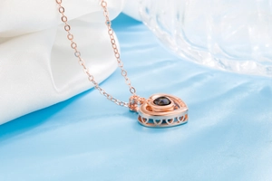 Macro view of rose gold heart necklace with LOVE engraving and black stone inlay