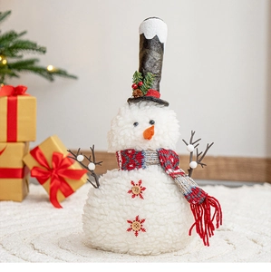 Close-up of plush Christmas snowman figurine with top hat and festive knitted scarf