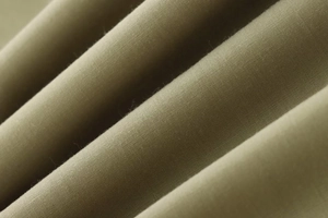 Macro detail of military green poplin fabric showing smooth texture and high-quality weave