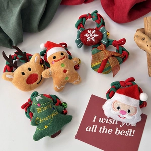 Détails des chouchous de Noël en peluche avec broderies du Père Noël et de rennes festifs