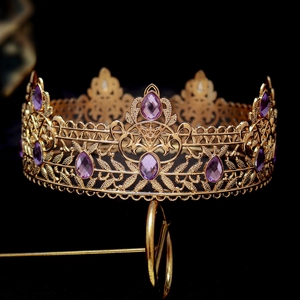 Detailed view of golden baroque crown featuring ornate hollow patterns and purple gems