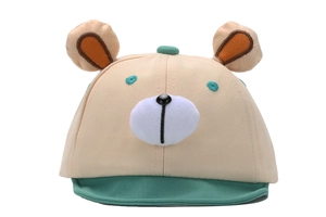 Detail of baby bear baseball cap with plush ears and embroidered face on beige cotton fabric