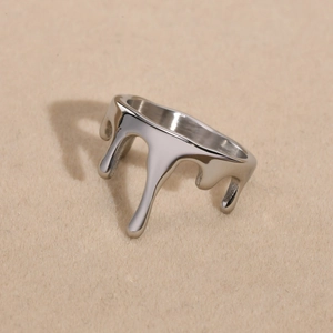 Macro shot of silver liquid lava drip ring with polished metallic finish on soft felt background