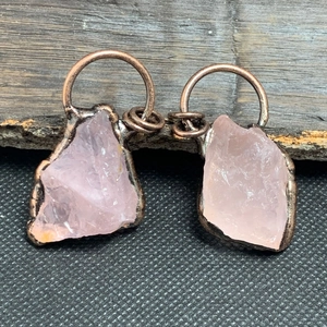 Dettaglio di pendenti in quarzo rosa naturale con bordo in metallo bronzo stile vintage