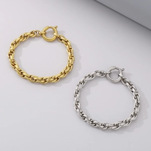 Macro detail of gold and silver chunky chain bracelets with textured spring ring clasps