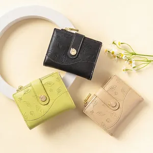 Three elegant bi-fold leaf embossed faux leather wallets with round floral metal buckles