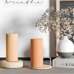 Close-up of orange striped pillar candles with vertical textures in a modern home setting