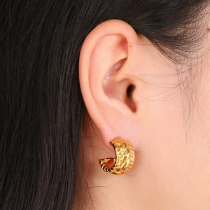 French vintage textured gold C-shape titanium steel hoop earrings worn by a model