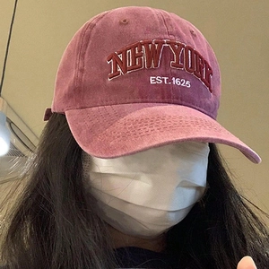 Close-up of vintage washed burgundy baseball cap featuring white New York embroidery