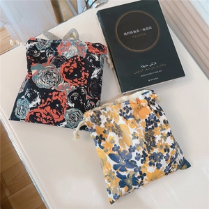 Detail view of cotton drawstring pouches with floral and rose patterns in oil painting style