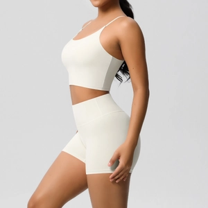 Detail view of cream-white yoga set featuring a strappy sports bra and high-waisted shorts