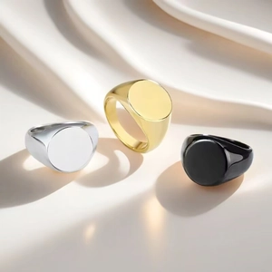 Primo piano di anelli a sigillo in acciaio al titanio nei colori oro, argento e nero