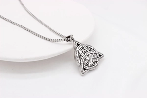 Detail of vintage silver Viking triangle pendant with moon, star, and engraved quotes
