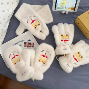 Details von flauschigem Schal und Handschuhen mit süßem Geburtstagskuchen-Stickereien