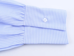 Close-up of blue pinstripe shirt cuff with white button detail and cotton texture